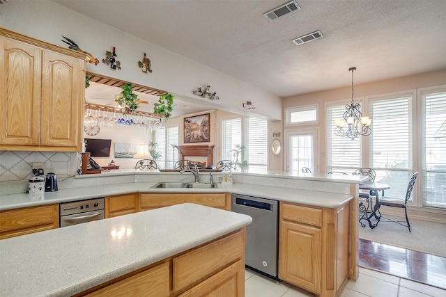 kitchen with a sink, visible vents, dishwasher, and light brown cabinetry