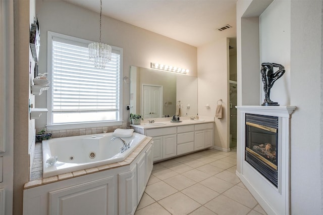 full bath with visible vents, a glass covered fireplace, a jetted tub, tile patterned flooring, and a sink