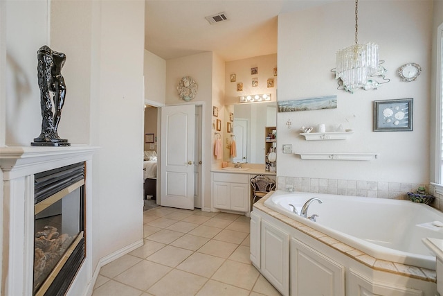 bathroom featuring connected bathroom, vanity, visible vents, a bath, and tile patterned floors