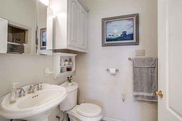 bathroom featuring a sink, toilet, and walk in shower