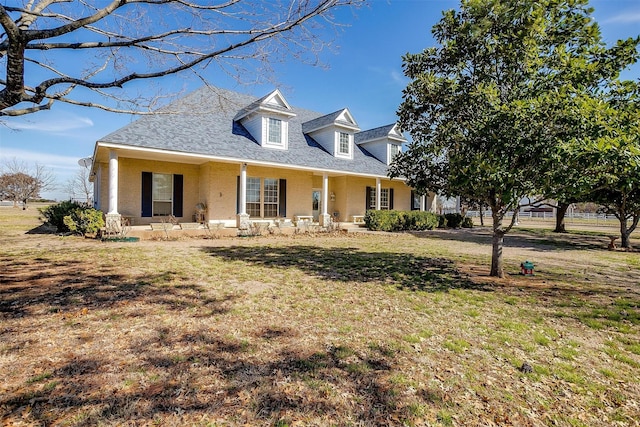 cape cod-style house with a front yard