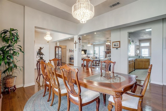 dining area featuring light wood-type flooring, visible vents, baseboards, and ceiling fan with notable chandelier