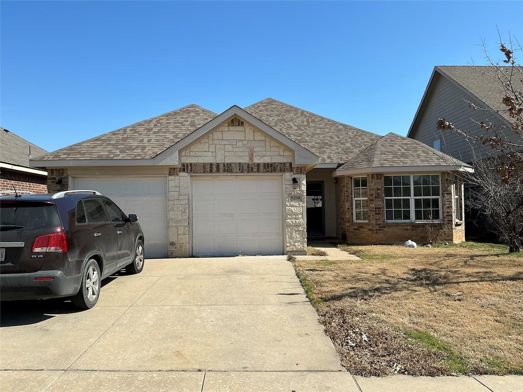 view of front of house featuring a garage, stone siding, concrete driveway, and roof with shingles