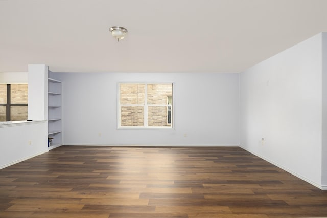 empty room featuring baseboards, plenty of natural light, and wood finished floors