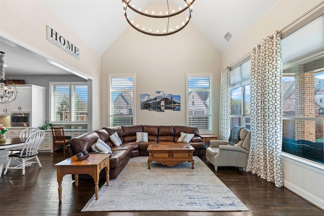 living area featuring dark wood-style floors, visible vents, a notable chandelier, and high vaulted ceiling