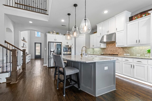 kitchen featuring recessed lighting, dark wood-style flooring, appliances with stainless steel finishes, and under cabinet range hood