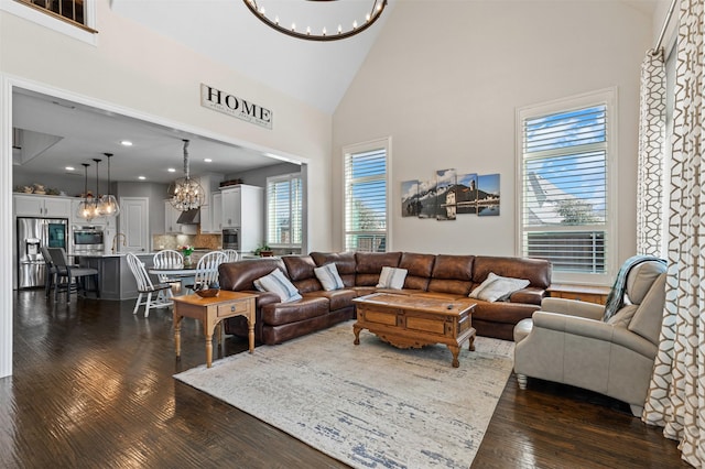 living area with high vaulted ceiling, recessed lighting, dark wood-type flooring, and a notable chandelier