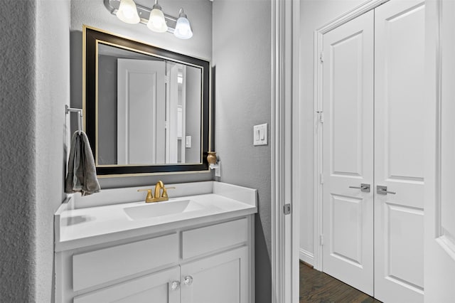 bathroom featuring a textured wall, wood finished floors, and vanity