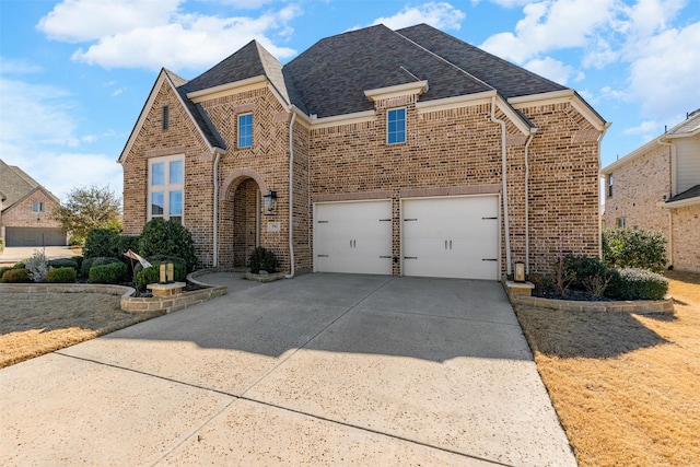 view of front of property featuring concrete driveway, brick siding, an attached garage, and a shingled roof