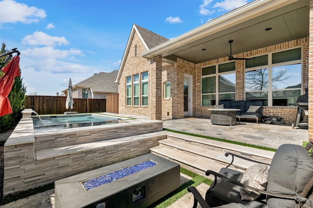 view of patio / terrace featuring fence and an outdoor living space with a fire pit