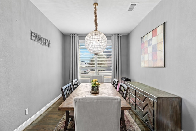 dining area with dark wood-style floors, an inviting chandelier, visible vents, and baseboards