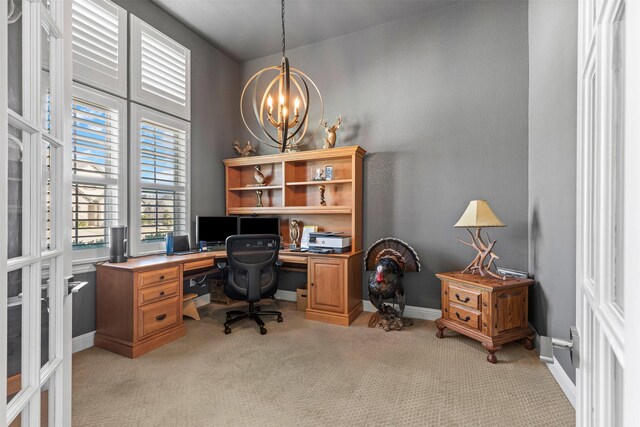 office featuring baseboards, a chandelier, and light carpet