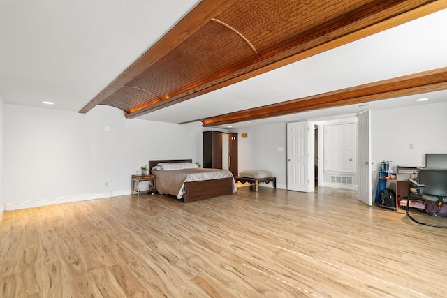 bedroom featuring beamed ceiling, light wood-type flooring, visible vents, and baseboards