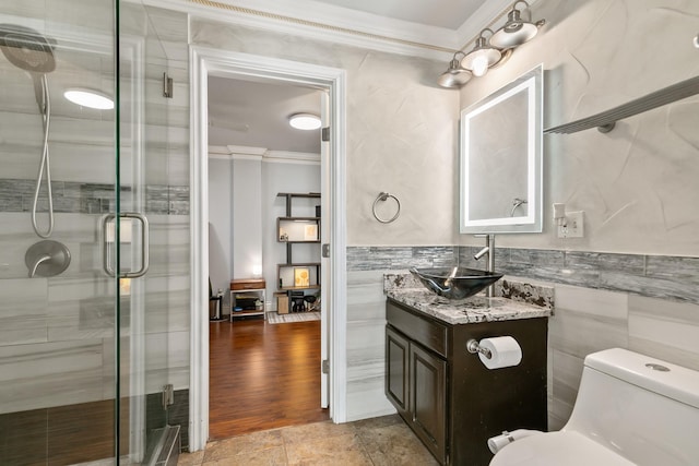 bathroom featuring ornamental molding, a stall shower, tile walls, and toilet