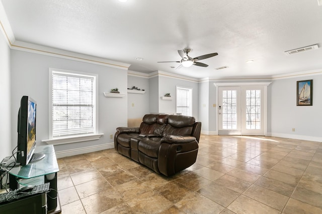 living area featuring baseboards, a textured ceiling, visible vents, and crown molding