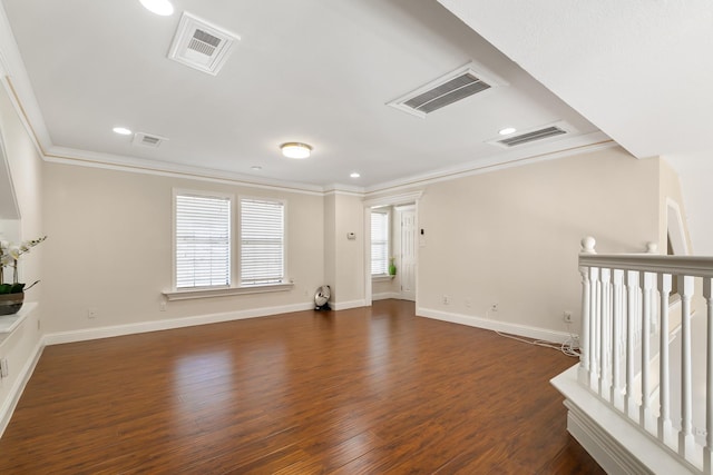 spare room with ornamental molding, wood finished floors, and visible vents