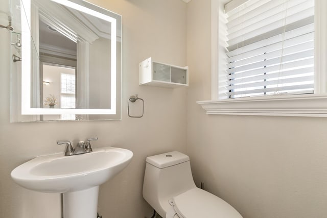 half bathroom featuring a sink and toilet