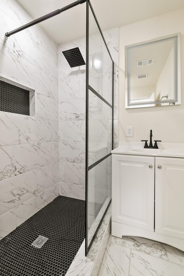 full bath featuring visible vents, marble finish floor, a stall shower, and vanity