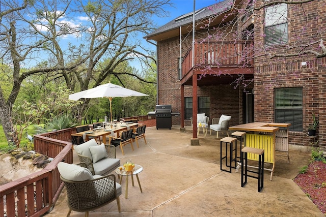 view of patio featuring outdoor dining space, a balcony, and area for grilling