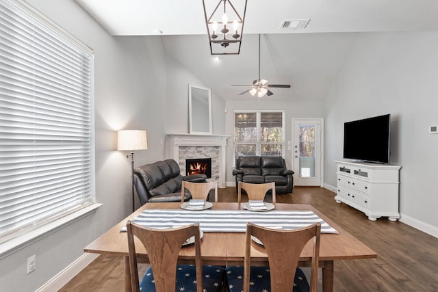 interior space featuring dark wood-type flooring, a fireplace, visible vents, baseboards, and vaulted ceiling