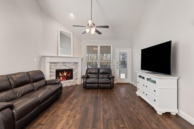 living room with dark wood-style floors, lofted ceiling, a fireplace, and baseboards