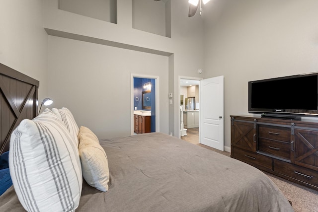 bedroom featuring connected bathroom and a towering ceiling