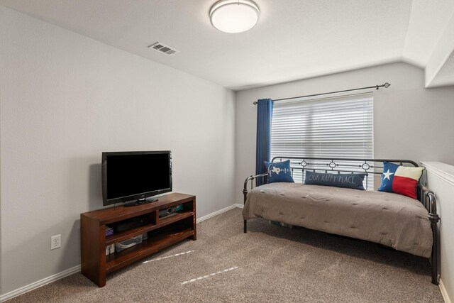 carpeted bedroom featuring baseboards, visible vents, and vaulted ceiling