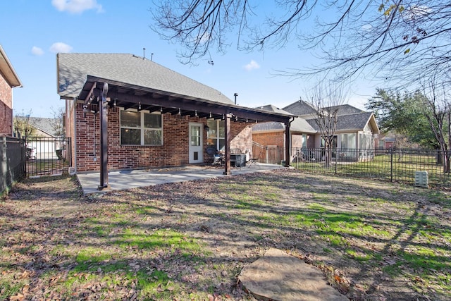 back of house with a patio, brick siding, and a fenced backyard