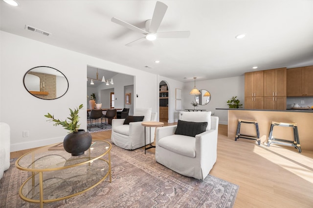 living room with recessed lighting, baseboards, visible vents, and light wood finished floors