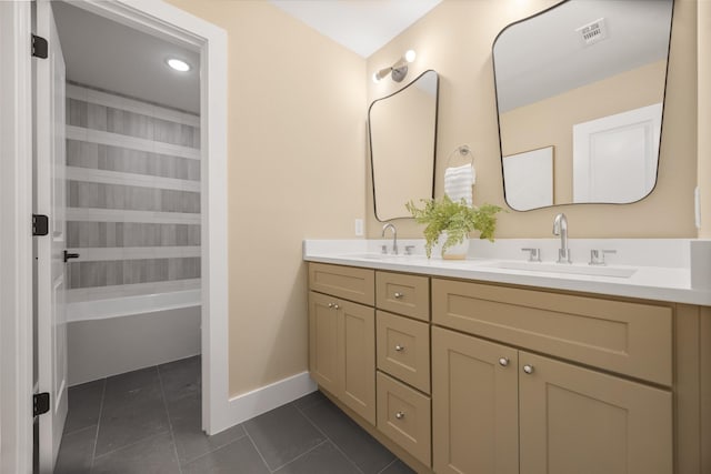 bathroom with double vanity, a sink, visible vents, and tile patterned floors