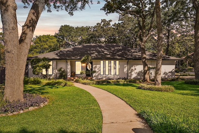 view of front of house featuring a lawn and brick siding