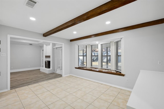 unfurnished living room with light tile patterned floors, visible vents, beamed ceiling, a brick fireplace, and recessed lighting