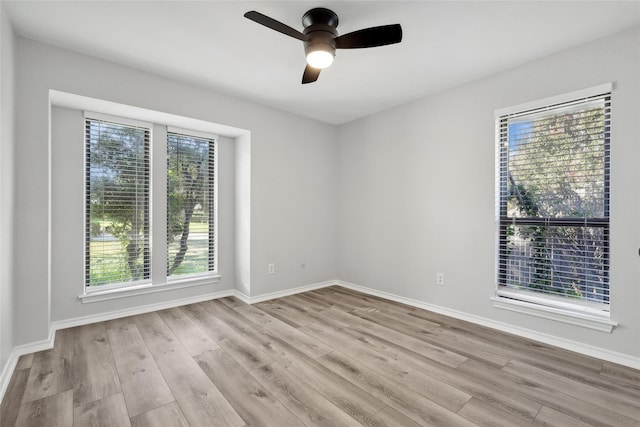 spare room with ceiling fan, wood finished floors, and baseboards