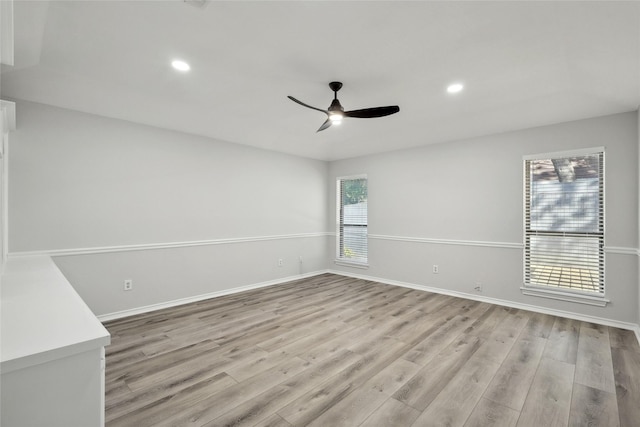 unfurnished room featuring baseboards, light wood finished floors, and a healthy amount of sunlight