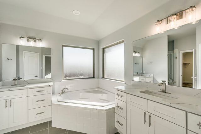 full bath with a garden tub, two vanities, a sink, a shower stall, and tile patterned flooring