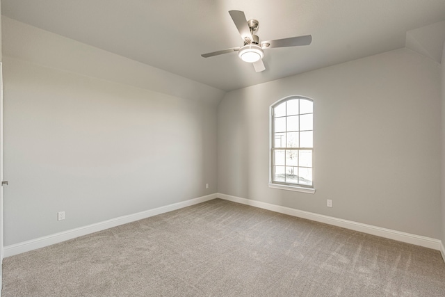 unfurnished room with vaulted ceiling, carpet flooring, a ceiling fan, and baseboards