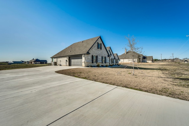 view of side of property featuring concrete driveway