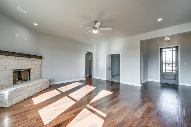 unfurnished living room featuring dark wood-style floors, a fireplace, visible vents, and ceiling fan with notable chandelier