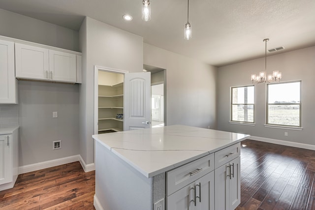 kitchen featuring visible vents, dark wood finished floors, baseboards, and white cabinetry