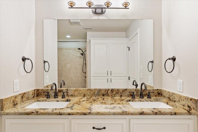806 N College Ave, West, TX 76691 - full bathroom with double vanity, a sink, and tiled shower