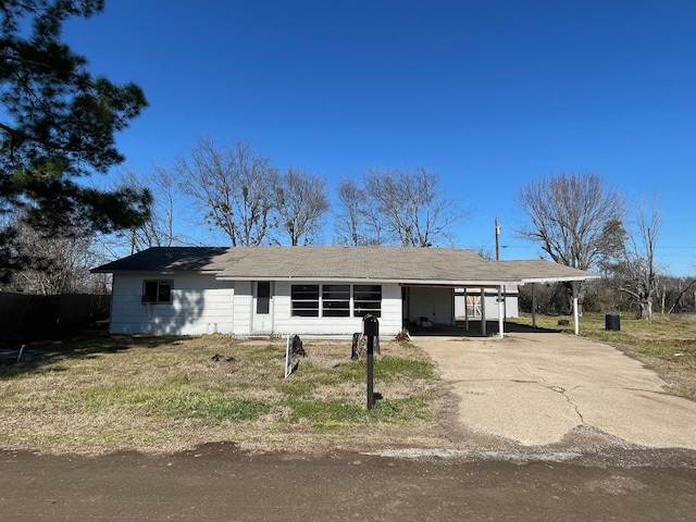 ranch-style home featuring a carport and driveway