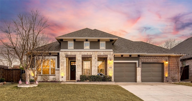 view of front of house with a garage, a lawn, concrete driveway, fence, and brick siding