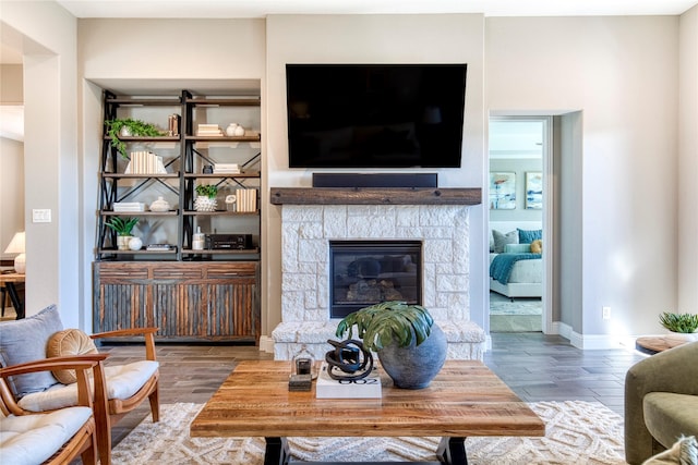 living room with a fireplace, wood finished floors, and baseboards