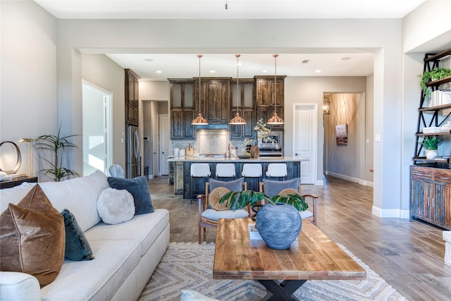 living room featuring light wood-style floors, baseboards, and recessed lighting