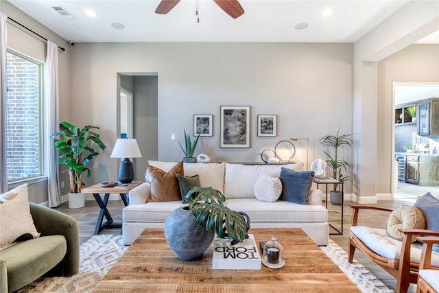 living room featuring light wood-type flooring, baseboards, visible vents, and recessed lighting