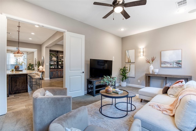 living room with a ceiling fan, recessed lighting, visible vents, and baseboards