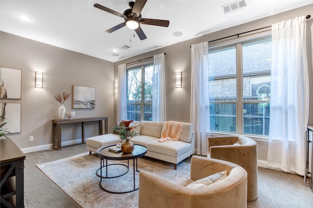 interior space with light carpet, baseboards, visible vents, and ceiling fan