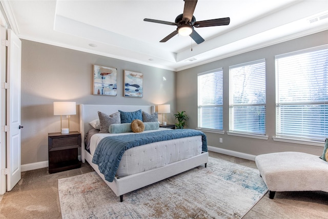 carpeted bedroom with ceiling fan, visible vents, baseboards, and a raised ceiling