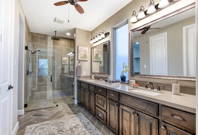 bathroom featuring double vanity, a stall shower, a sink, and visible vents