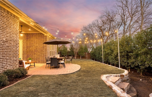 yard at dusk with fence and a patio